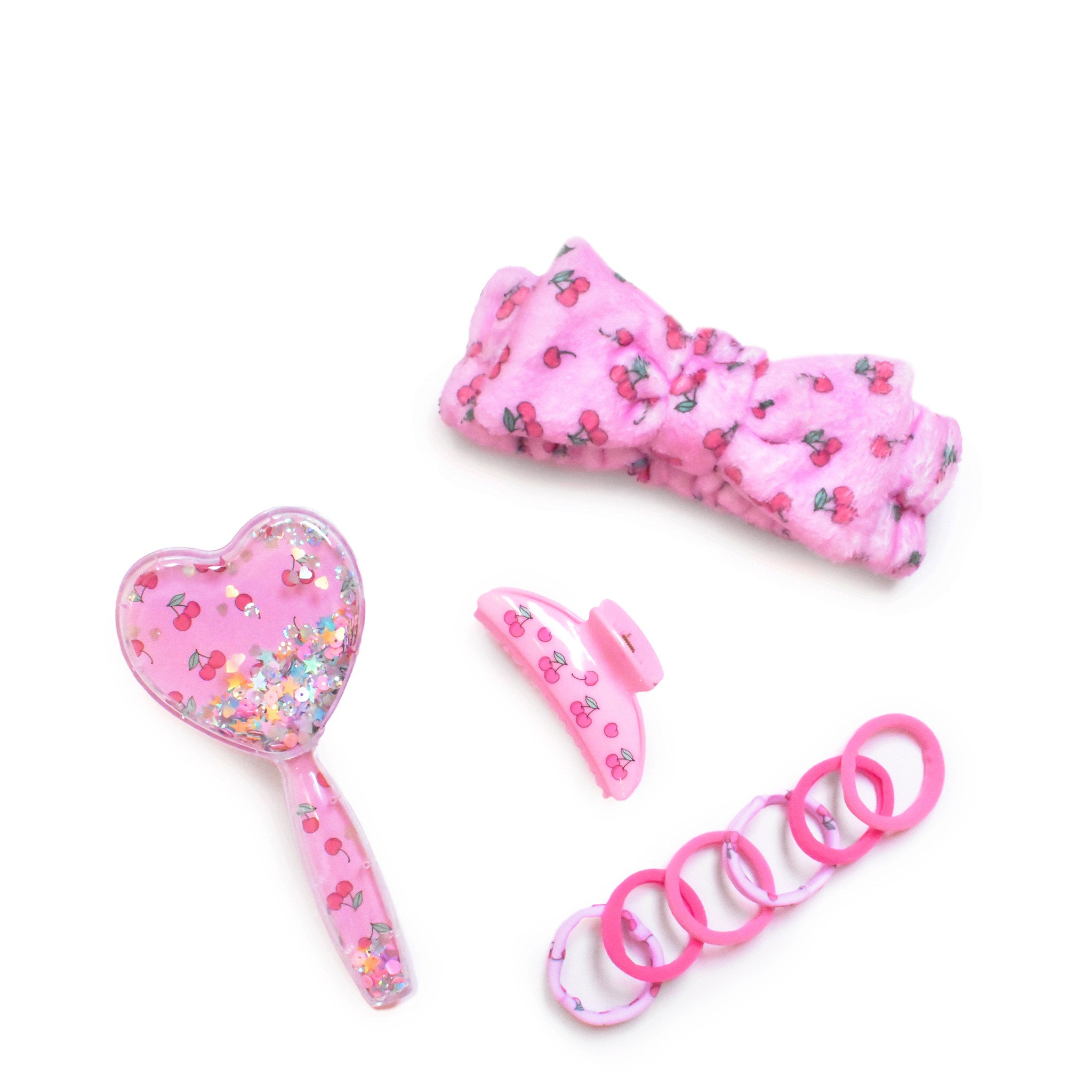 image of a cherry-printed spa kit with a hairbrush, spa headband, hair ties, & claw clip