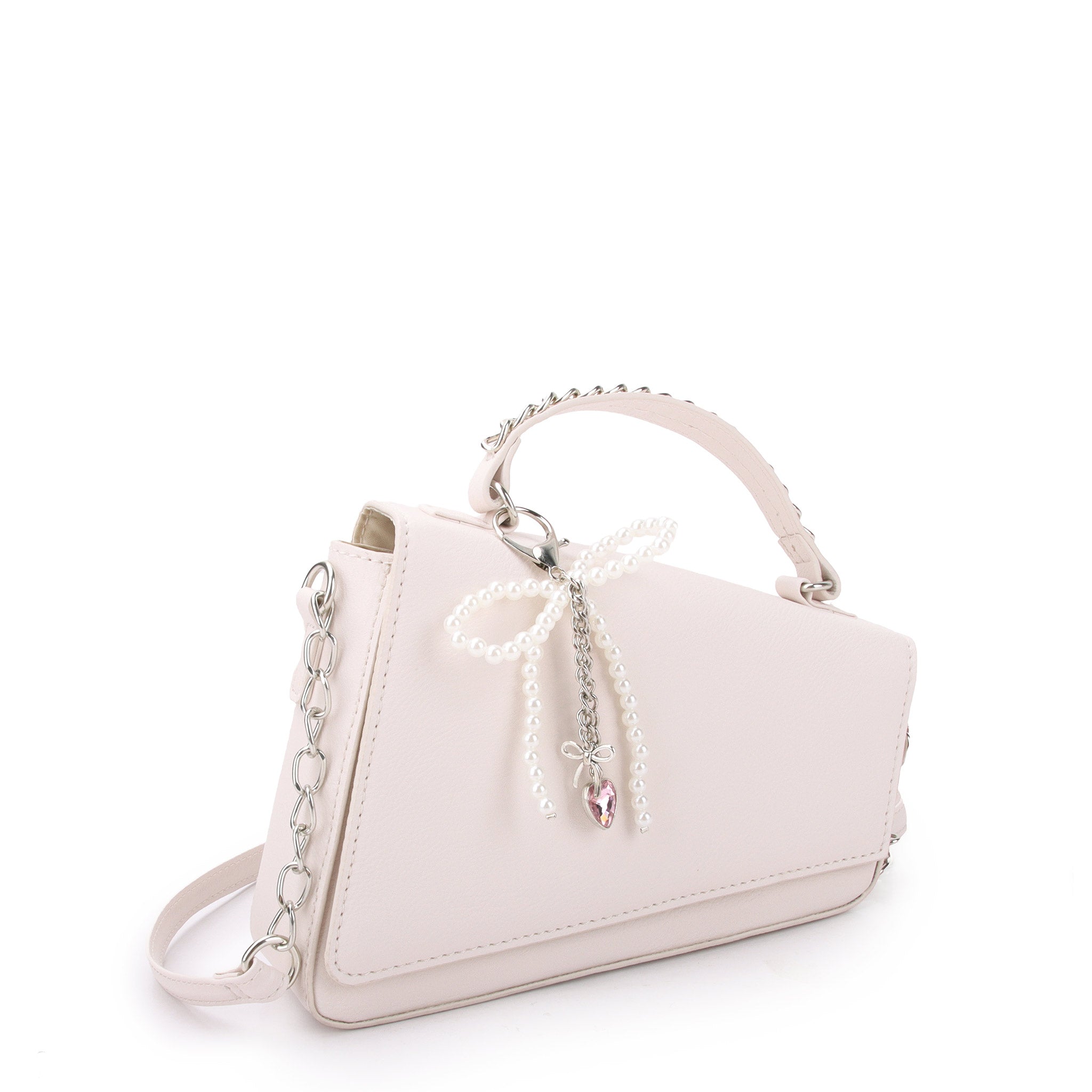 side view of a t view of white angled flap front crossbody bag with a pearl bow charm