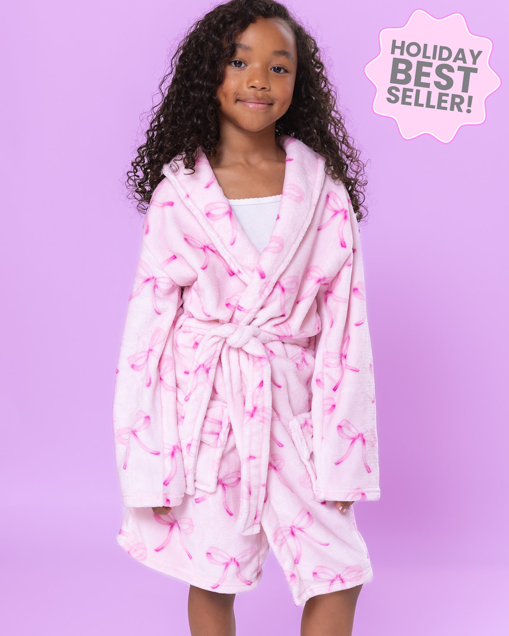 Girl wearing a pink bow print robe with a purple background