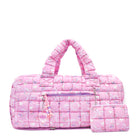 front facing view of a pink large sized quilted scrunch nylon duffle bag with a bow and heart  print and front beaded zipper pocket with a crystal heart charm and matching detachable coin pouch