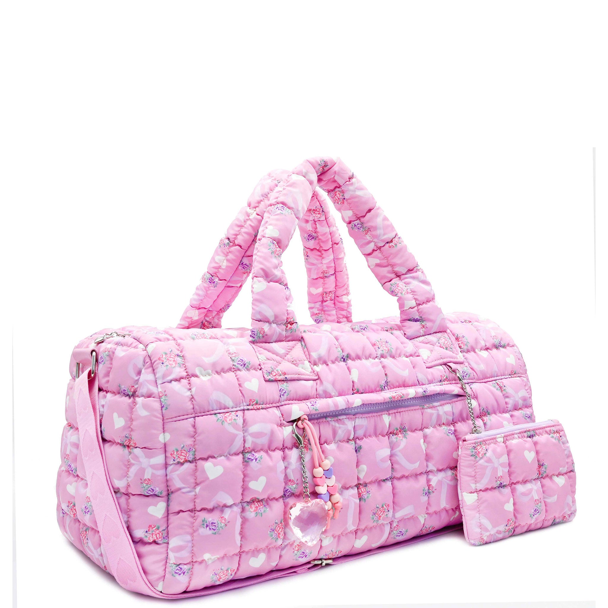 3/4 facing view of a pink large sized quilted scrunch nylon duffle bag with a bow and heart print and front beaded zipper pocket with a crystal heart charm and matching detachable coin pouch