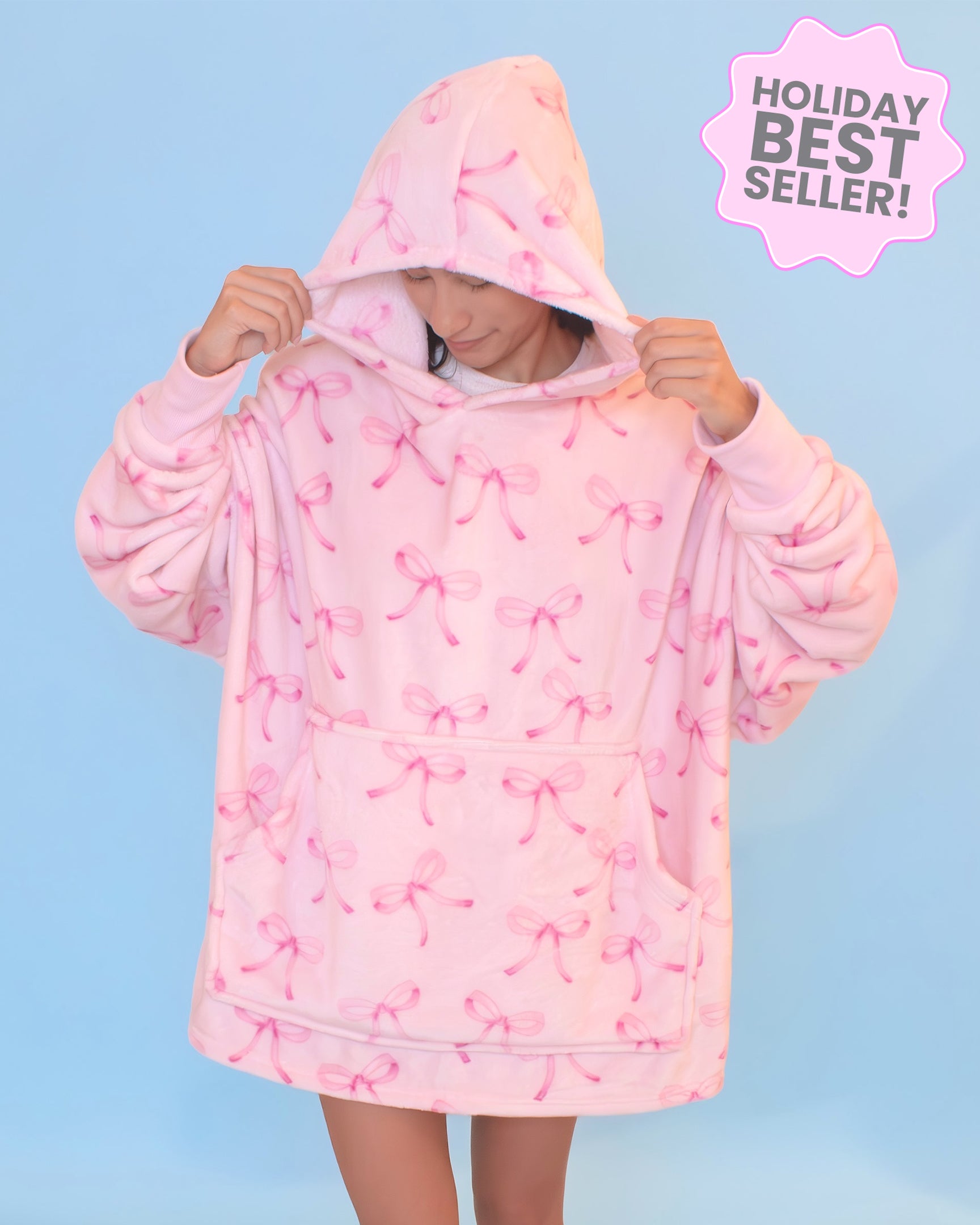 Photo of a girl wearing an oversized pink bow blanket hoodie