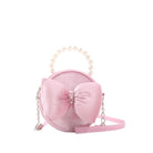 Pink velvet circle shaped bag with a large puffy velvet bow on the front and pearl detailing with a pearl top handle