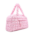 3/4 acing view of a pink medium sized quilted scrunch nylon duffle bag with a cherry print and front beaded zipper pocket with a crystal heart charm