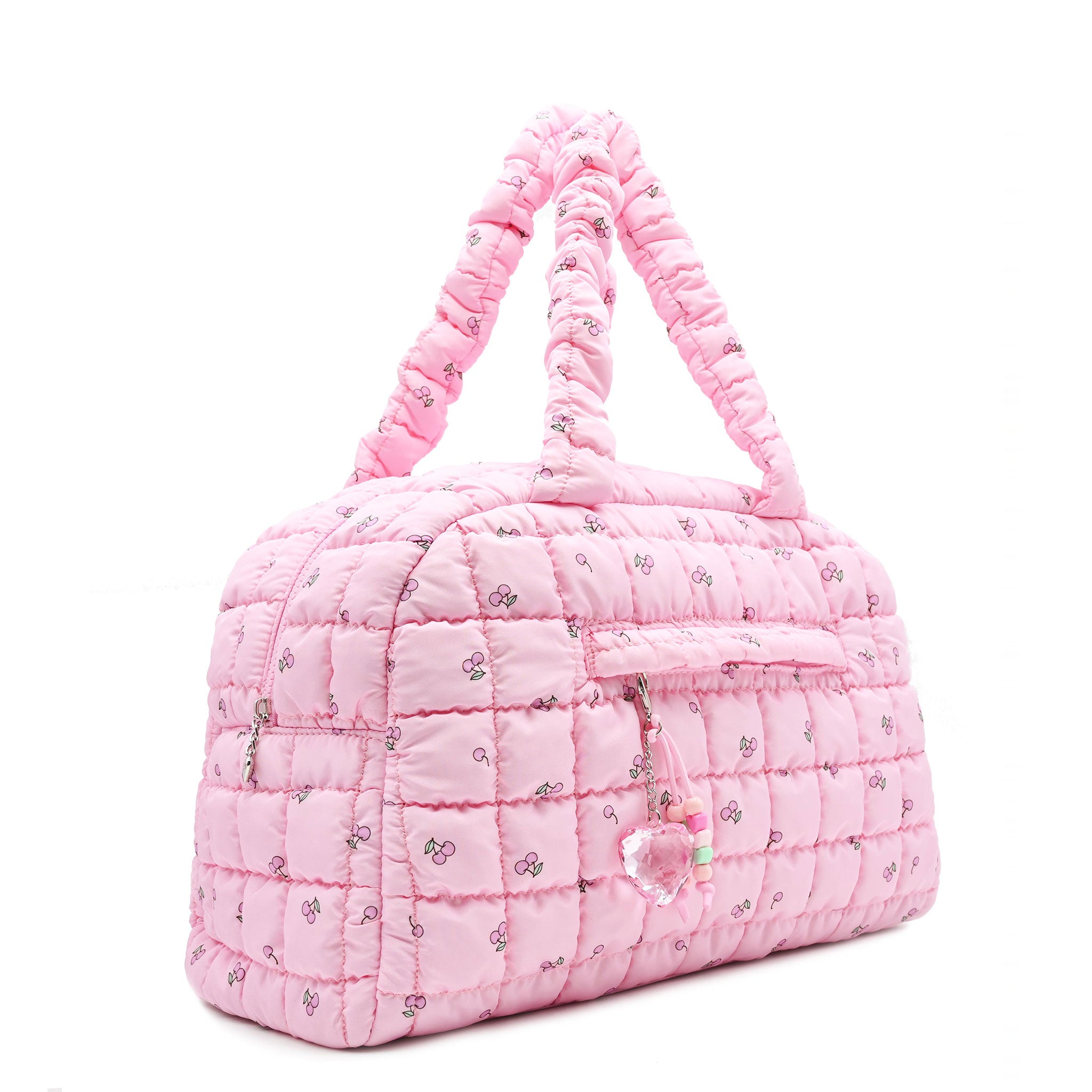3/4 acing view of a pink medium sized quilted scrunch nylon duffle bag with a cherry print and front beaded zipper pocket with a crystal heart charm