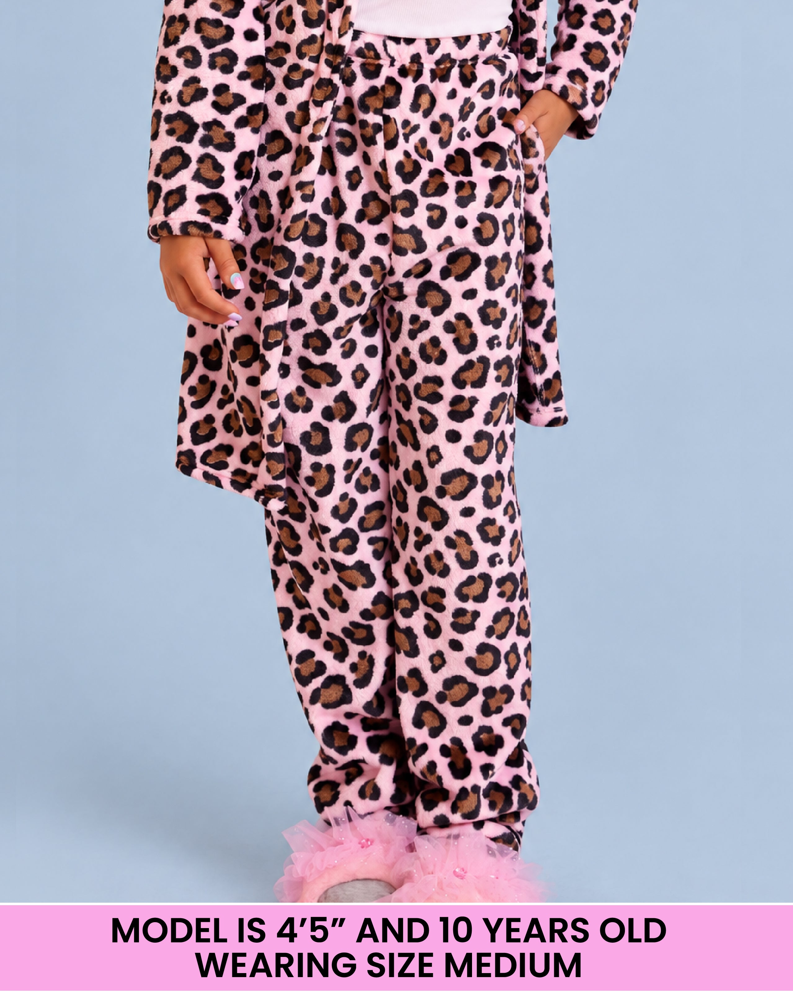 A child wearing a pink leopard-print pajama pants, standing against a light blue background. A pink text banner at the bottom reads 'MODEL IS 4'5" AND 10 YEARS OLD WEARING SIZE MEDIUM'.