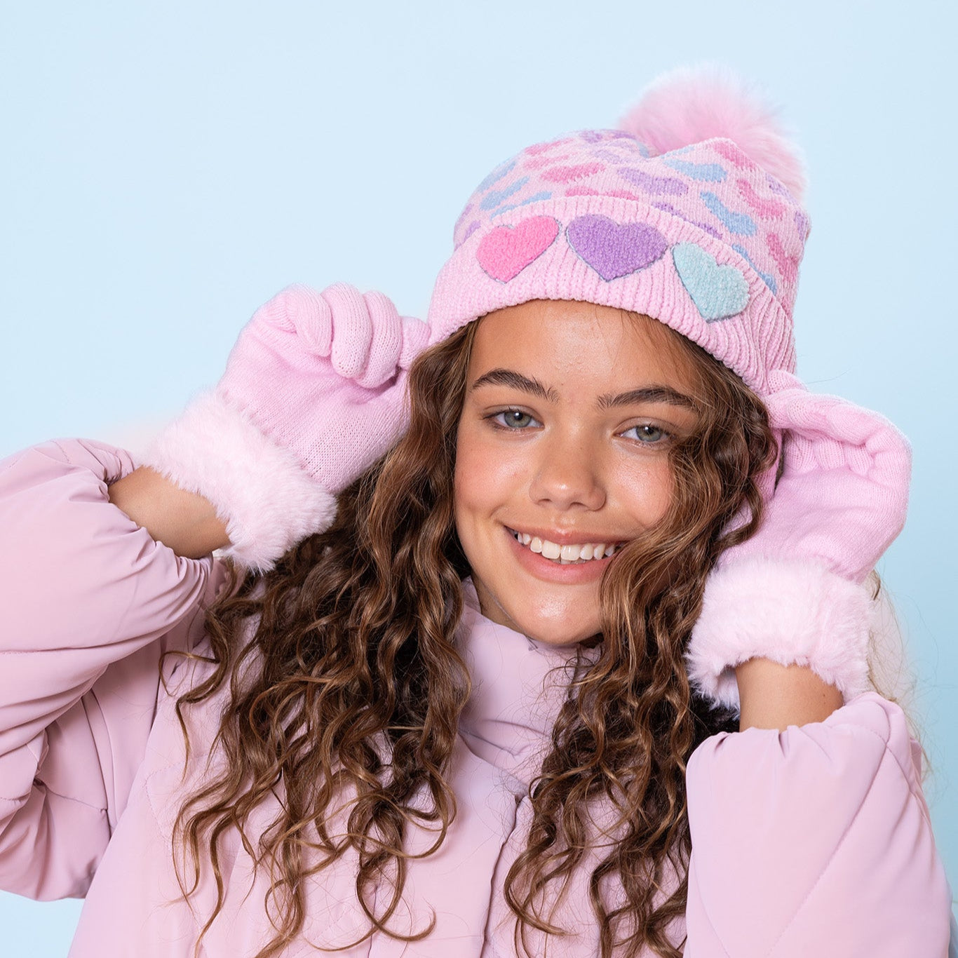 model wearing pink chenille heart printed pom pom beanie with heart patched