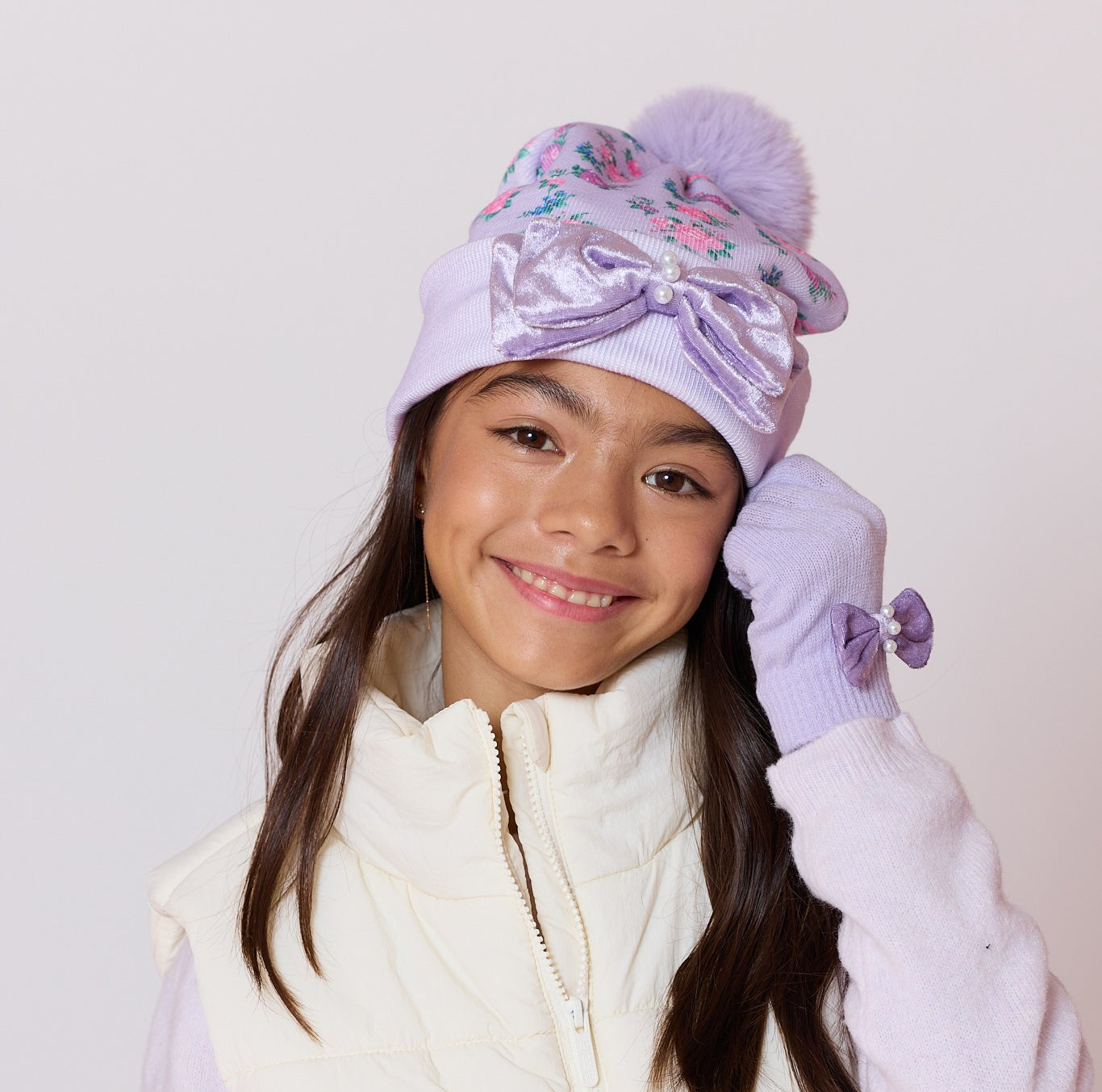 model wearing a purple floral print pom pom hat with matching gloves