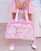 Photoshoot image of pink bow print duffle bag