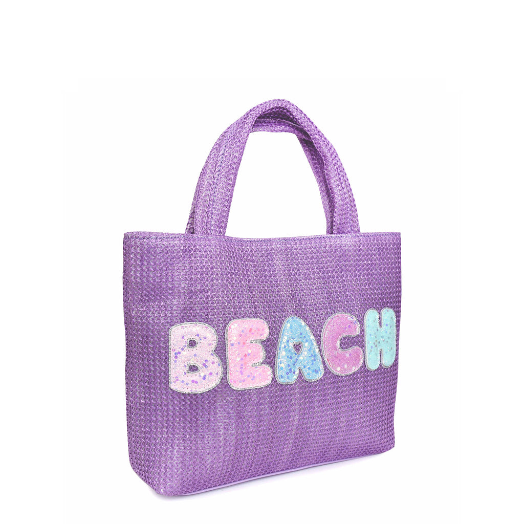 Side view of purple straw mini tote bag embellished with glitter bubble letter 'BEACH' appliqué