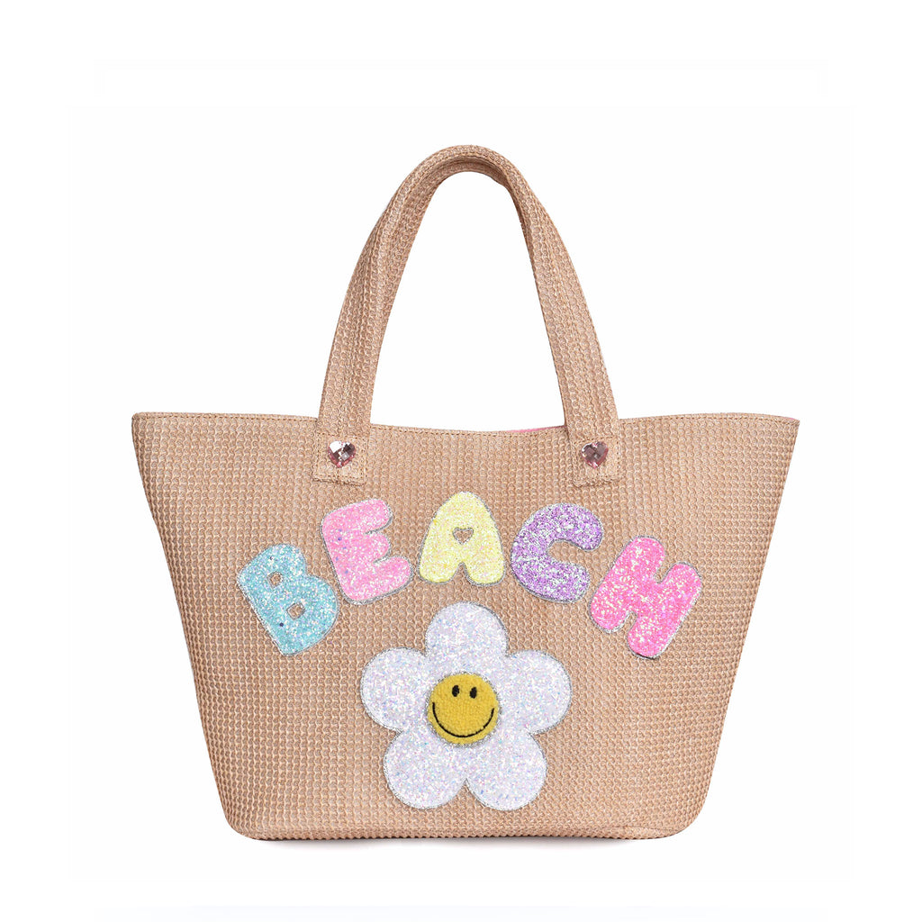 Front view of straw 'Beach' tote bag with glitter daisy and bubble-letter patches