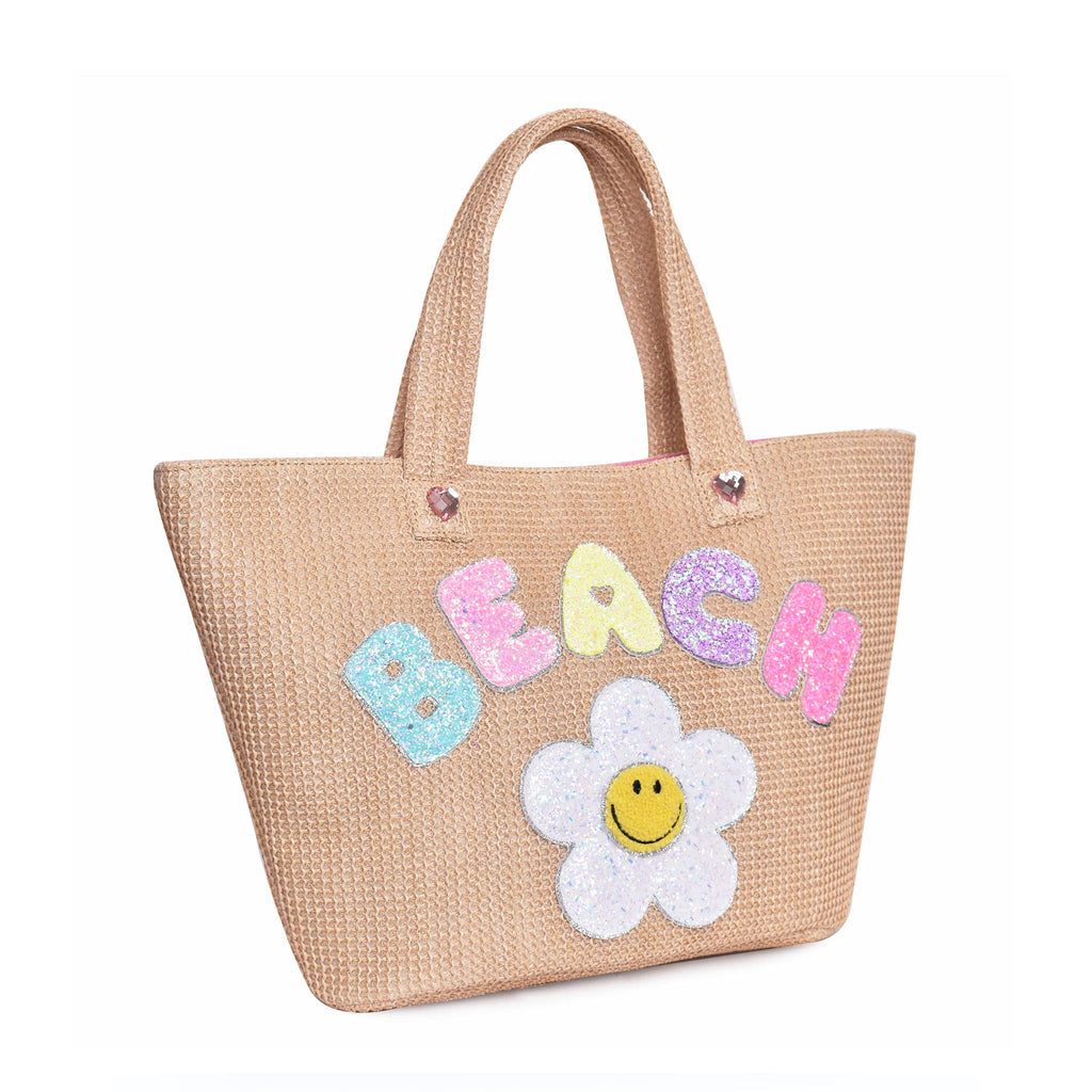 Side view of straw 'Beach' tote bag with glitter daisy and bubble-letter patches