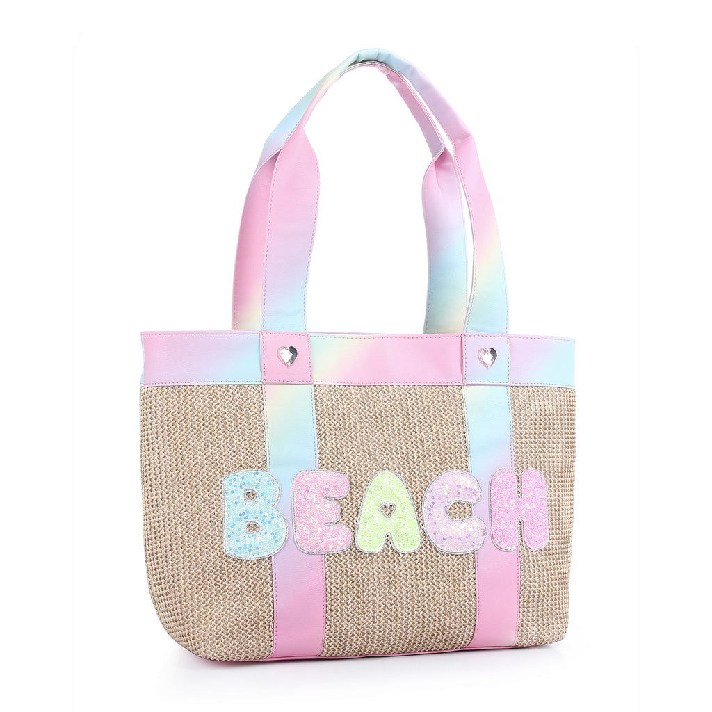 Sideview of straw beach tote bag with glitter bubble letters' 'BEACH' and ombre straps
