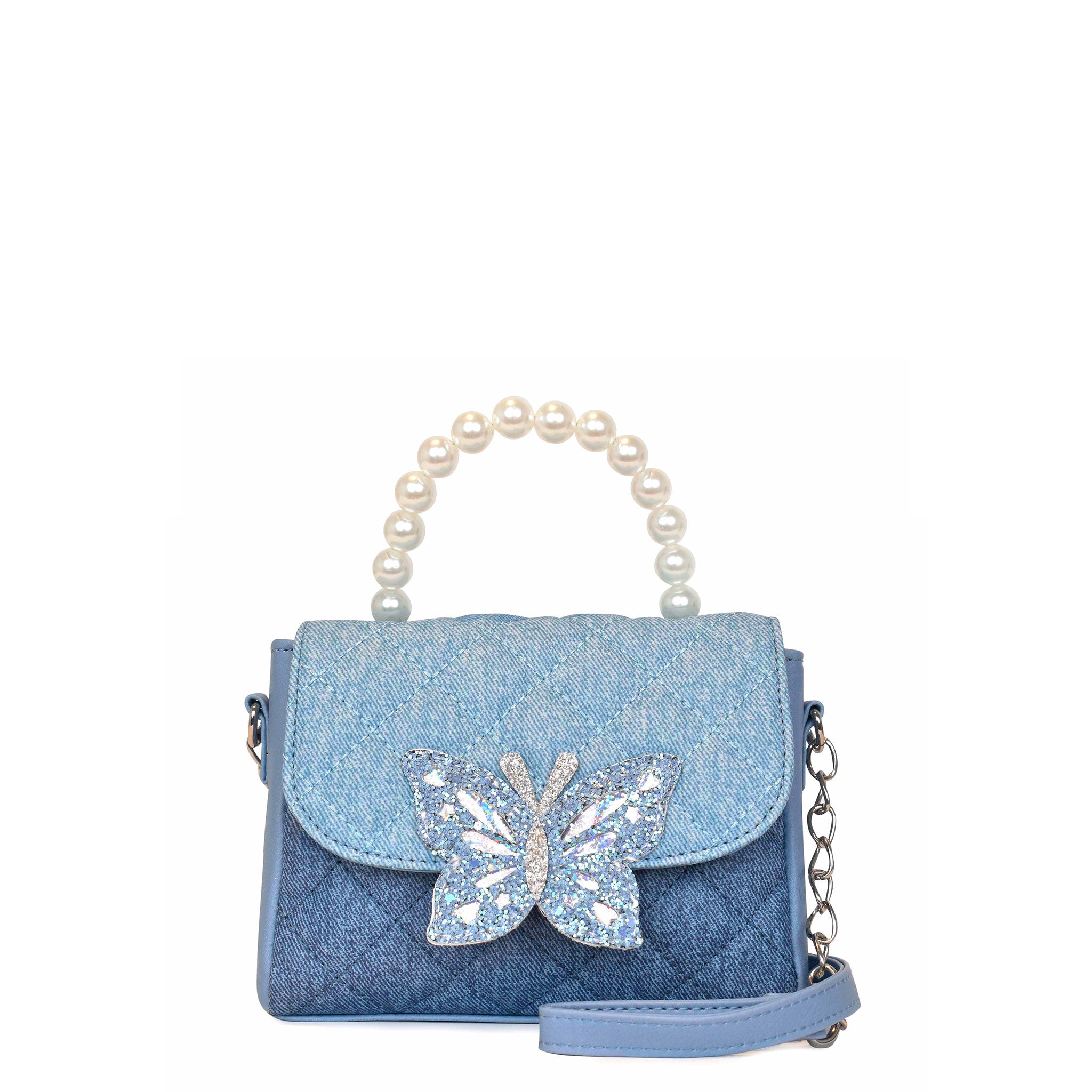 Front view of a two-toned denim quilted flap top crossbody with a pearl top handle and glitter butterfly closure button patch