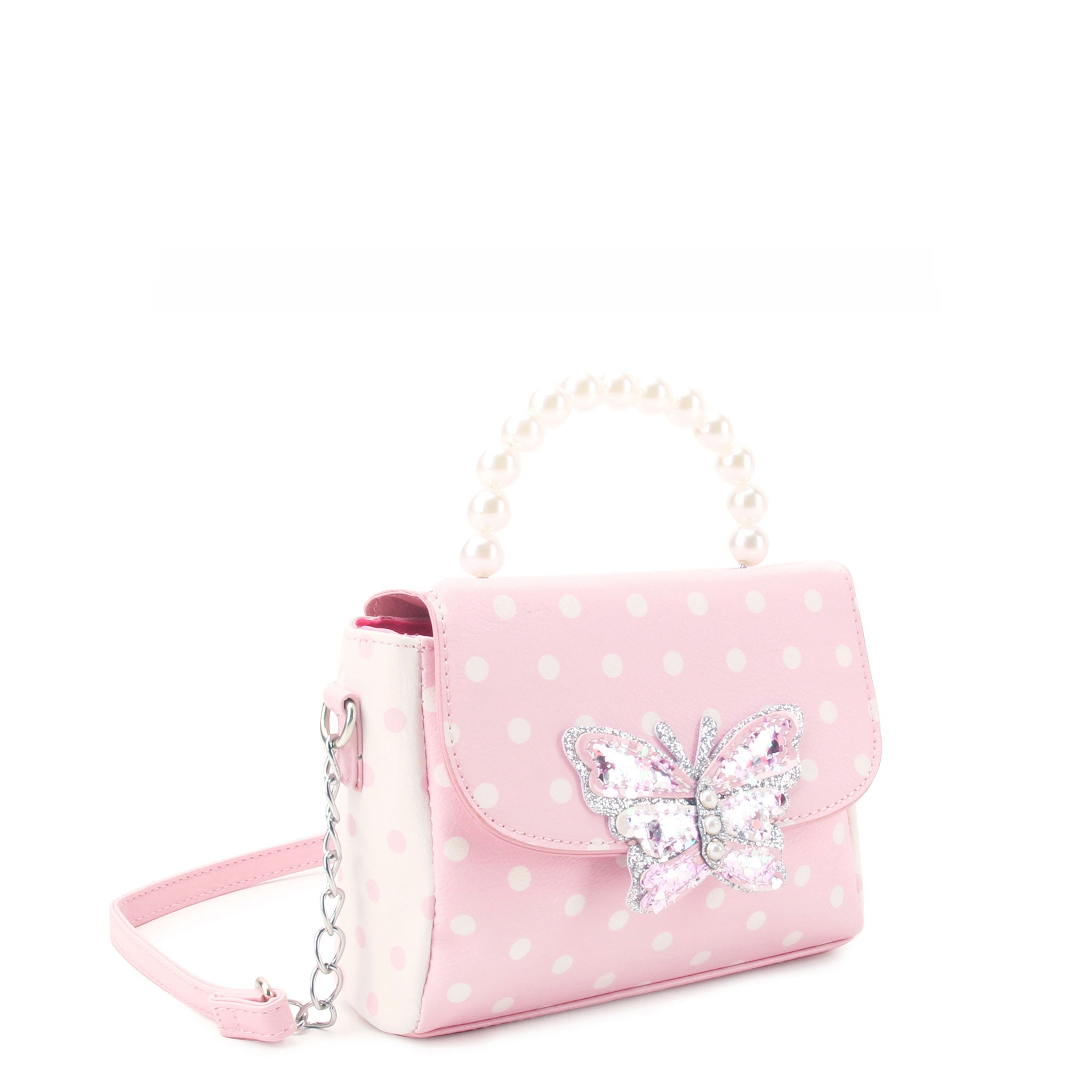 side view of a polka dotted mini bag with a confetti filled butterfly applique nd a pearl handle top handle 