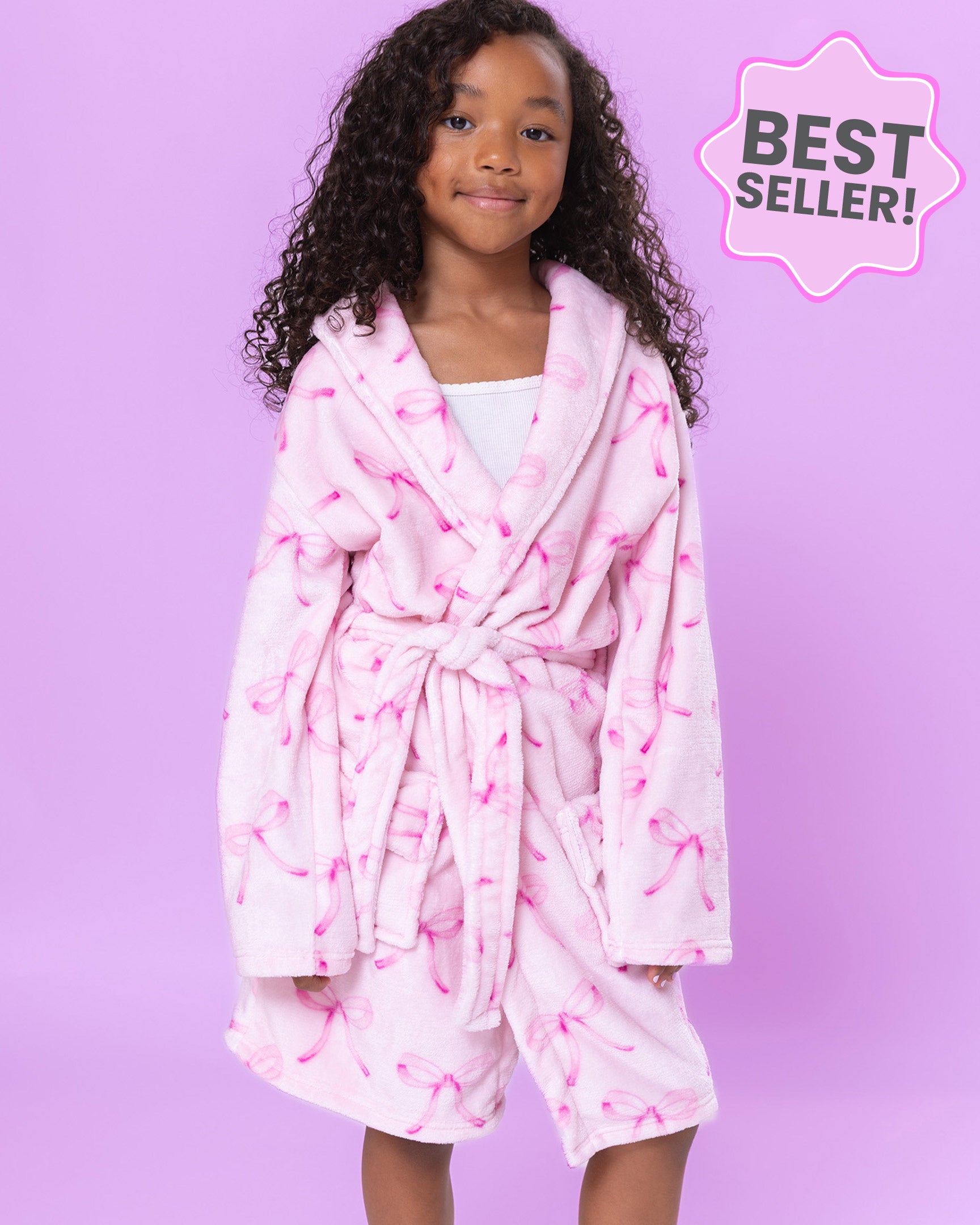 Girl wearing a pink bow print robe with a purple background