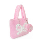 A pink plush tote bag with a white bow applique and a matching pink pom-pom charm featuring a pearlized star, shown on a plain white background.