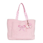 A light pink fuzzy tote bag with matching pink shoulder straps, featuring an embroidered pink bow on the front and a bow-shaped charm with a rhinestone accent.