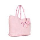 A light pink fuzzy tote bag with matching pink shoulder straps, featuring an embroidered pink bow on the front and a bow-shaped charm with a rhinestone accent.