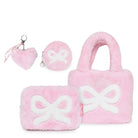 A pink plush gift set containing a large bow-patterned mini tote, a small round pouch , a plush heart and faux pearl keychain, and a small rectangular pouch, all in soft pink with white bow accents.