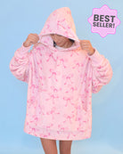 Photo of a girl wearing an oversized pink bow blanket hoodie