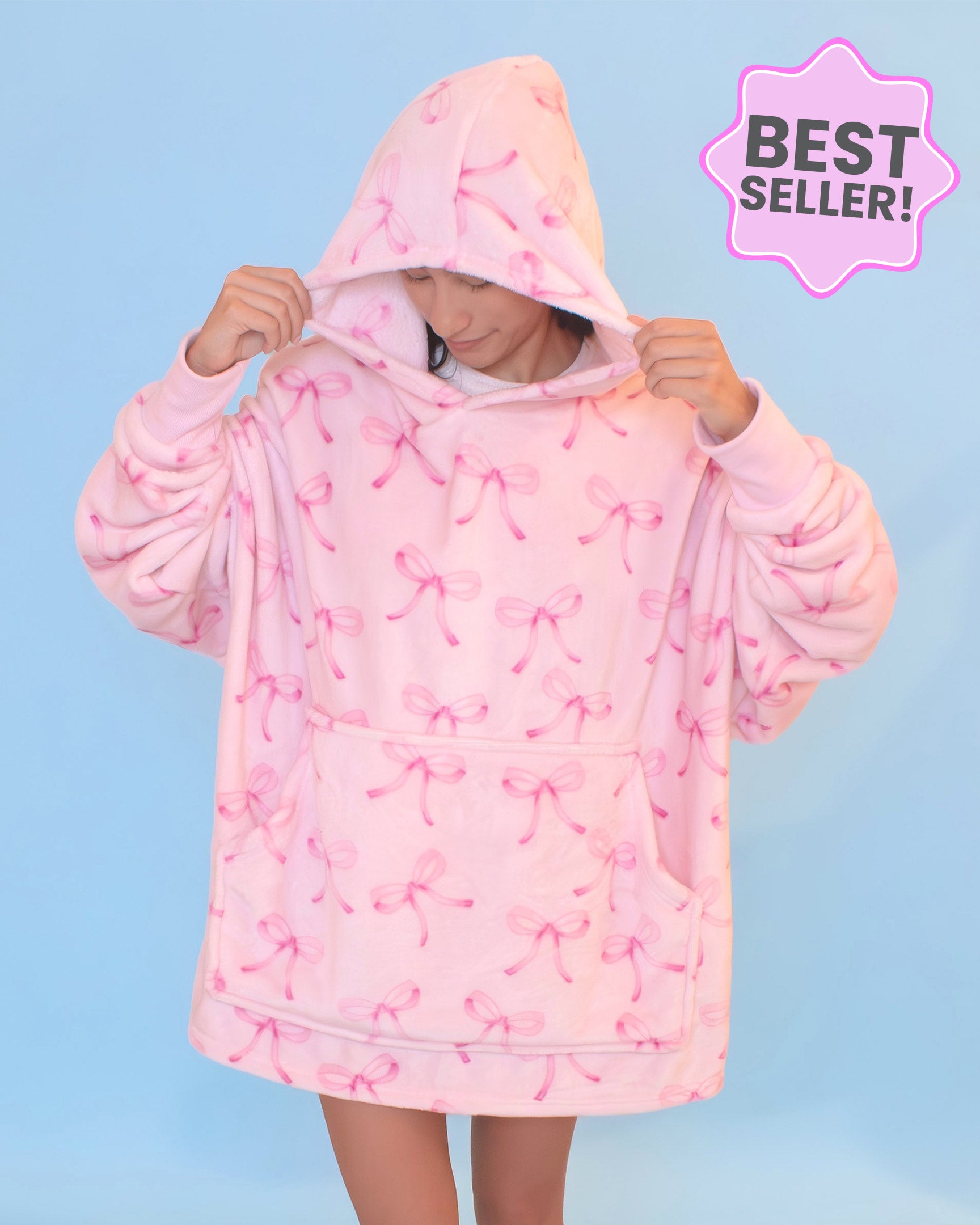 Photo of a girl wearing an oversized pink bow blanket hoodie