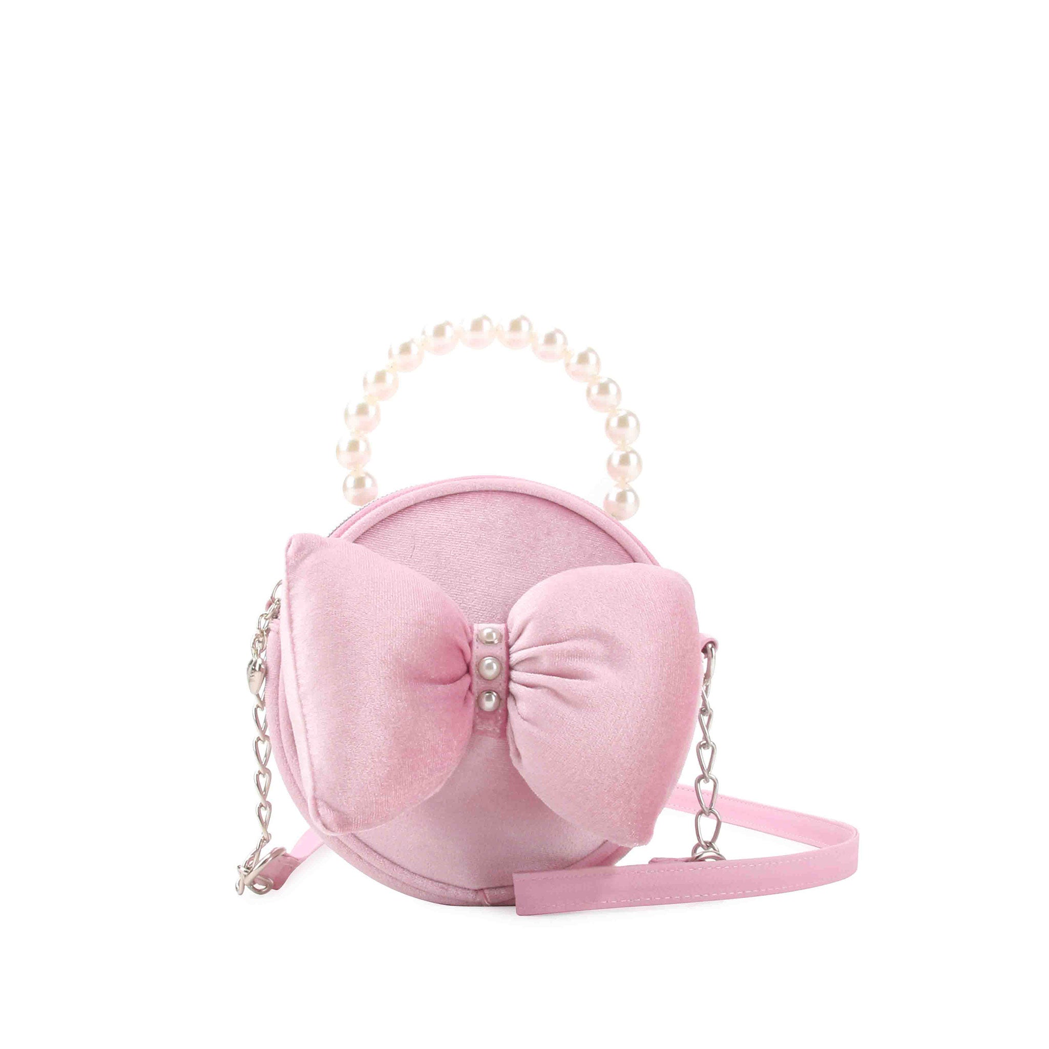 Pink velvet circle shaped bag with a large puffy velvet bow on the front and pearl detailing with a pearl top handle