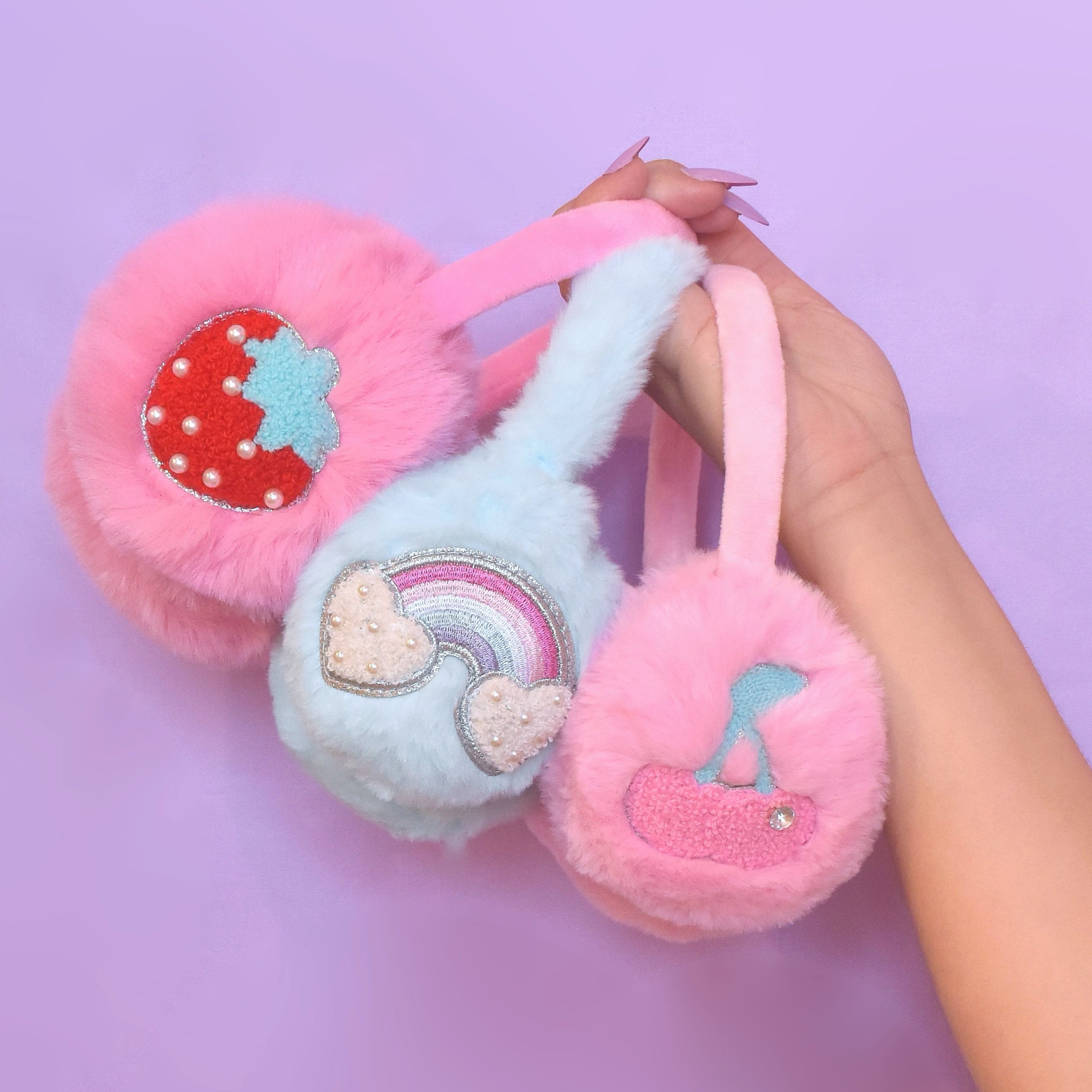 Plush ear muffs held against a purple background