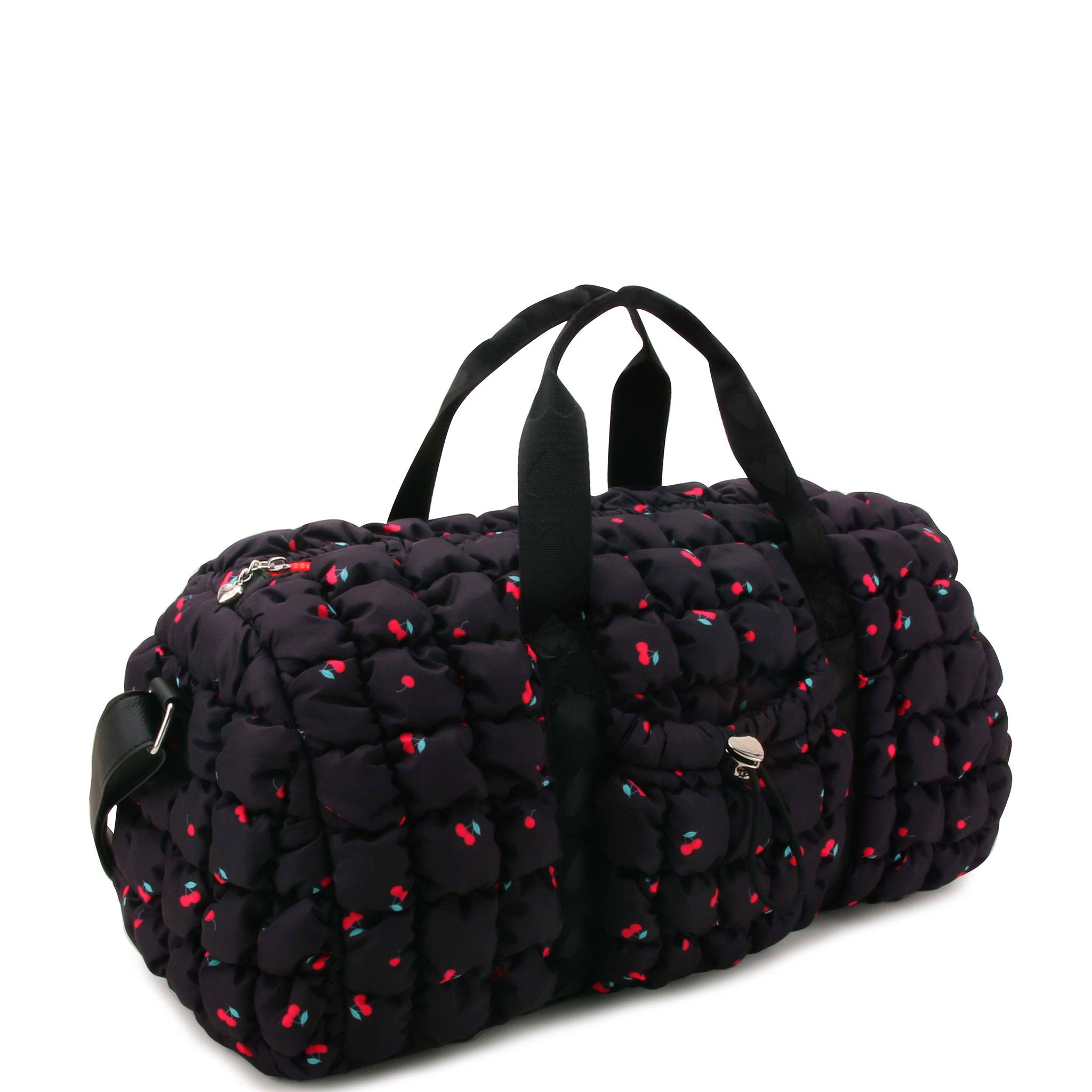 3/4 angle view of a black quilted duffle with red cherry print and a crossbody strap