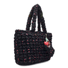 side view of a black cherry printed nylon quilted tote bag with cherry print & a cherry charm keychain 