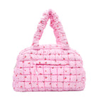 front view of a pink quilted nylon medium duffle in a cherry print