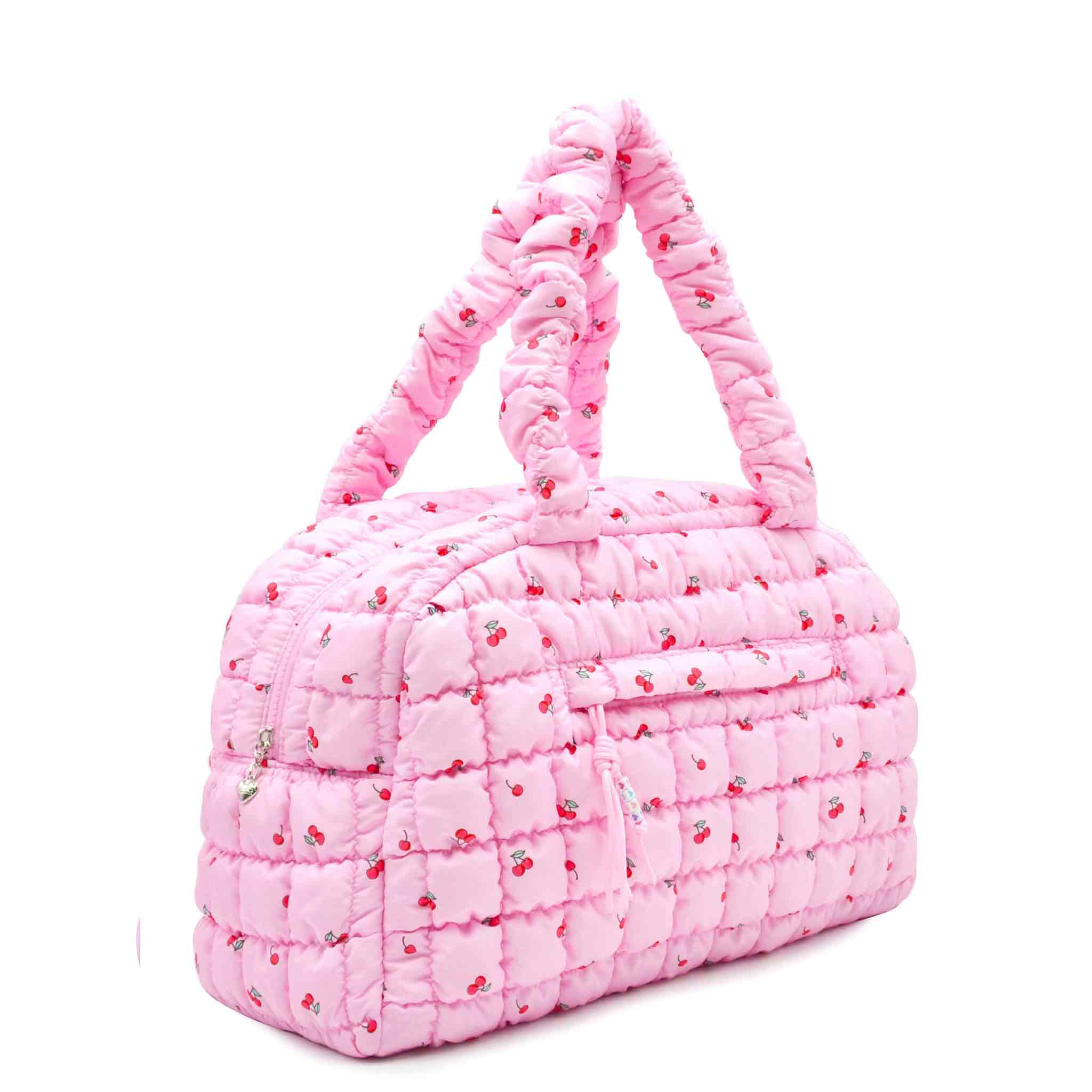 side view of a pink quilted nylon medium duffle in a cherry print