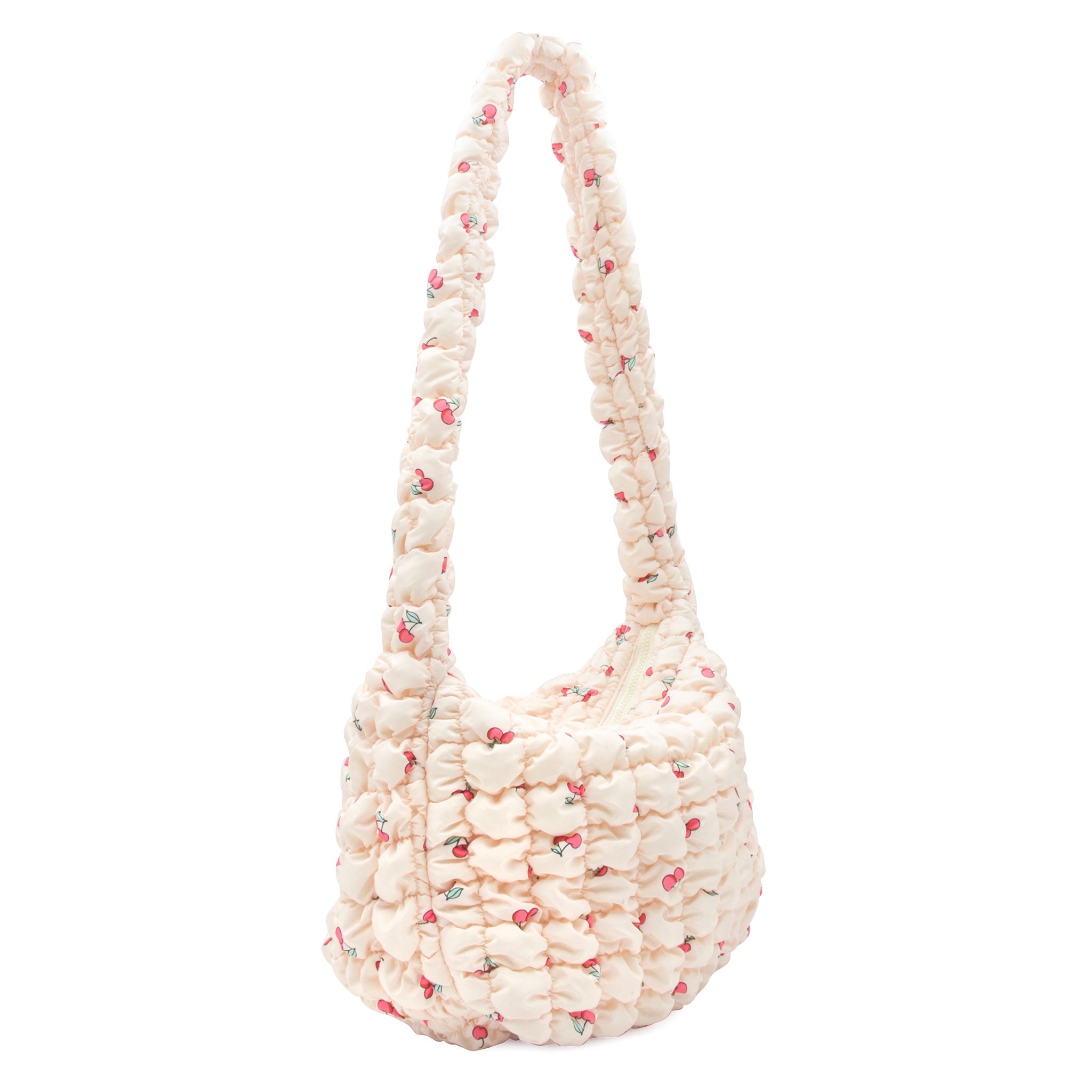 side view of a natural colored cherry print quilted nylon hobo style crossbody sling bag