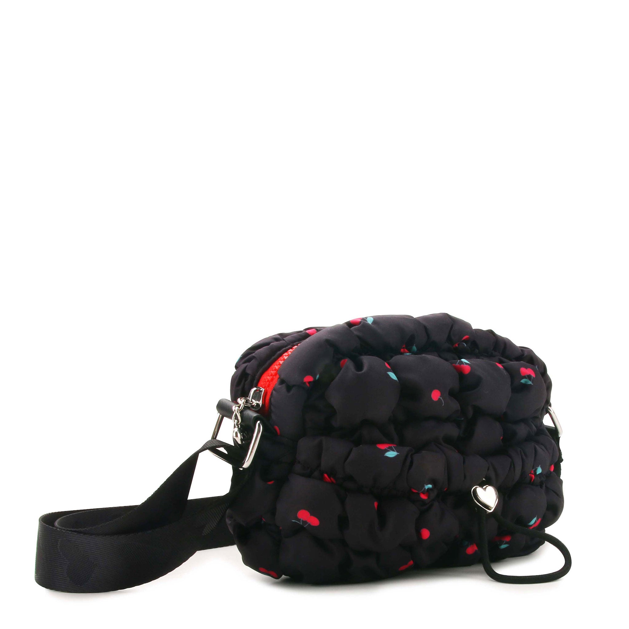 3/4 angle view of a black quilted crossbody with red cherry print