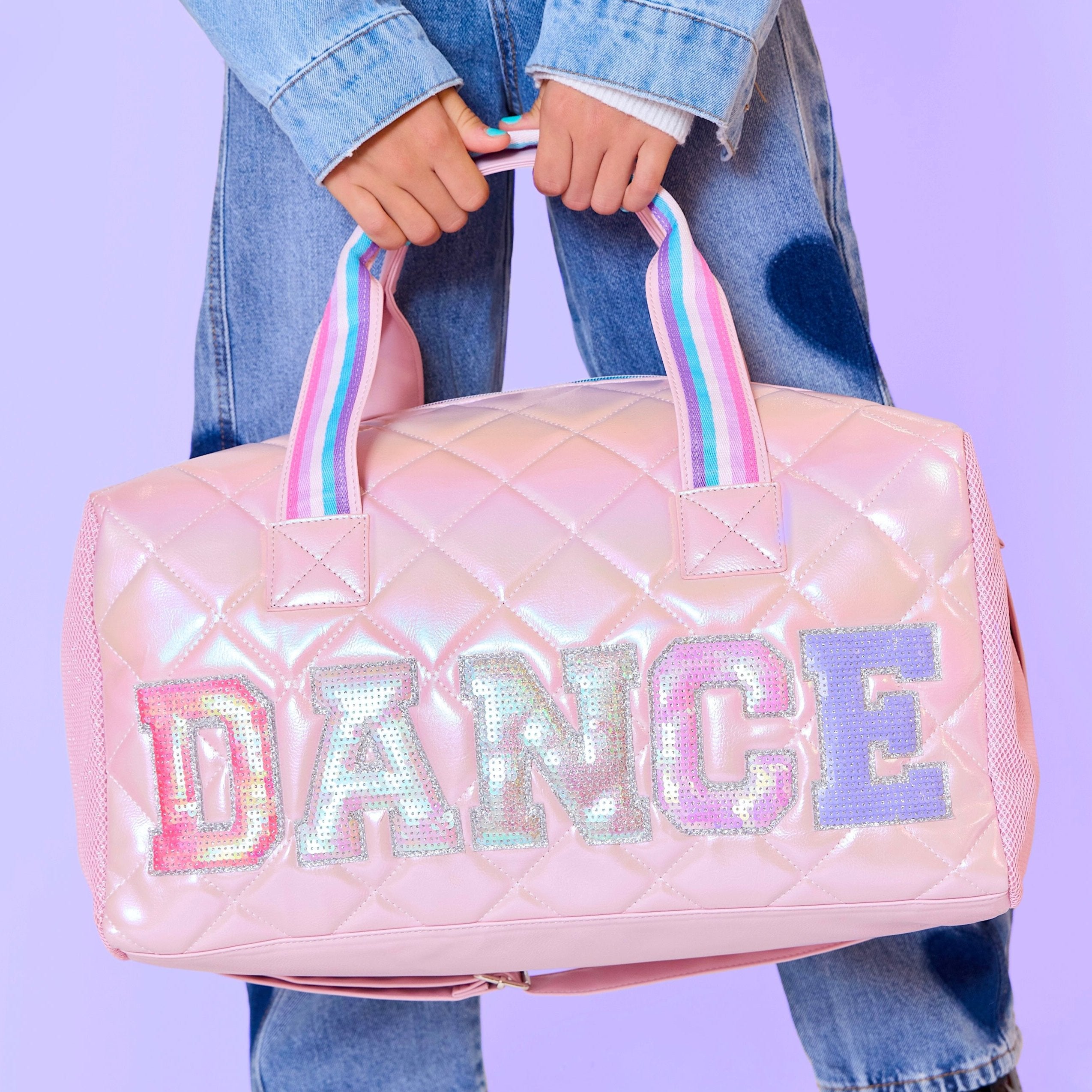 photoshoot photo of a pink metallic large duffle bag with sequin applique letters 'DANCE'  appliqué  