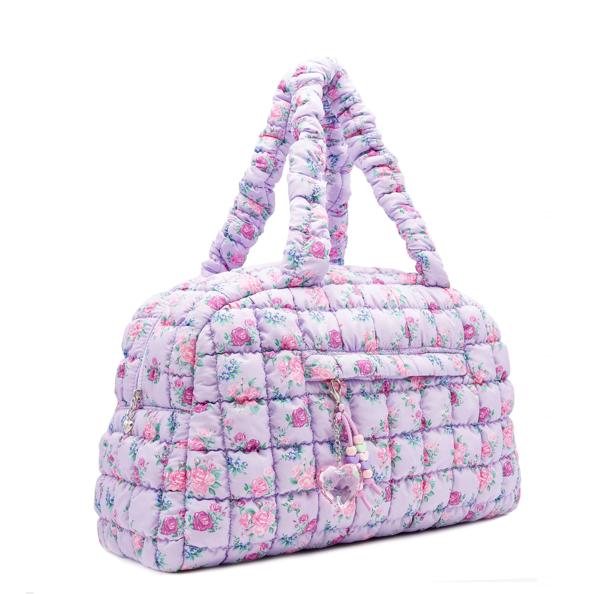 3/4 facing view of a purple medium sized quilted scrunch nylon duffle bag with a floral print and front beaded zipper pocket with a crystal heart charm