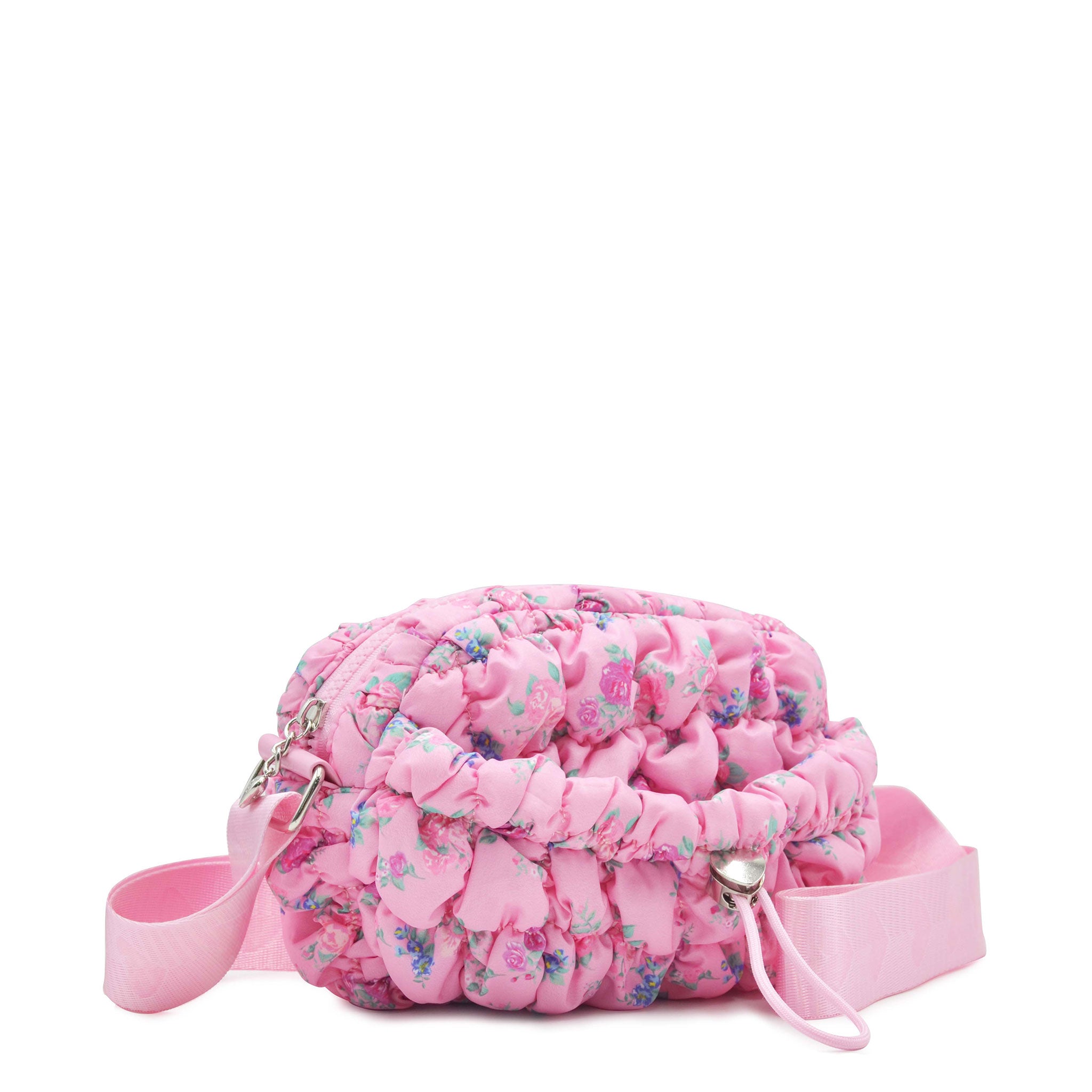 side view of a pink floral print nylon quilted mini crossbody bag with drawstring closure and a heart strap