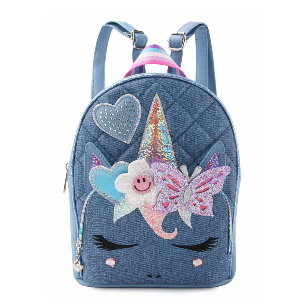Front view of a denim quilted unicorn face mini backpack with glitter butterfly, heart, and happy face flower appliqués