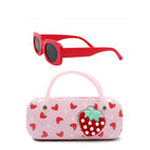 Pink sunglasses case with strawberry design and red sunglasses on a white background