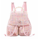 Front View of a Pink tweed drawstring mini backpack, with two front pockets, pearl handles, and rhinestone heart snap closures