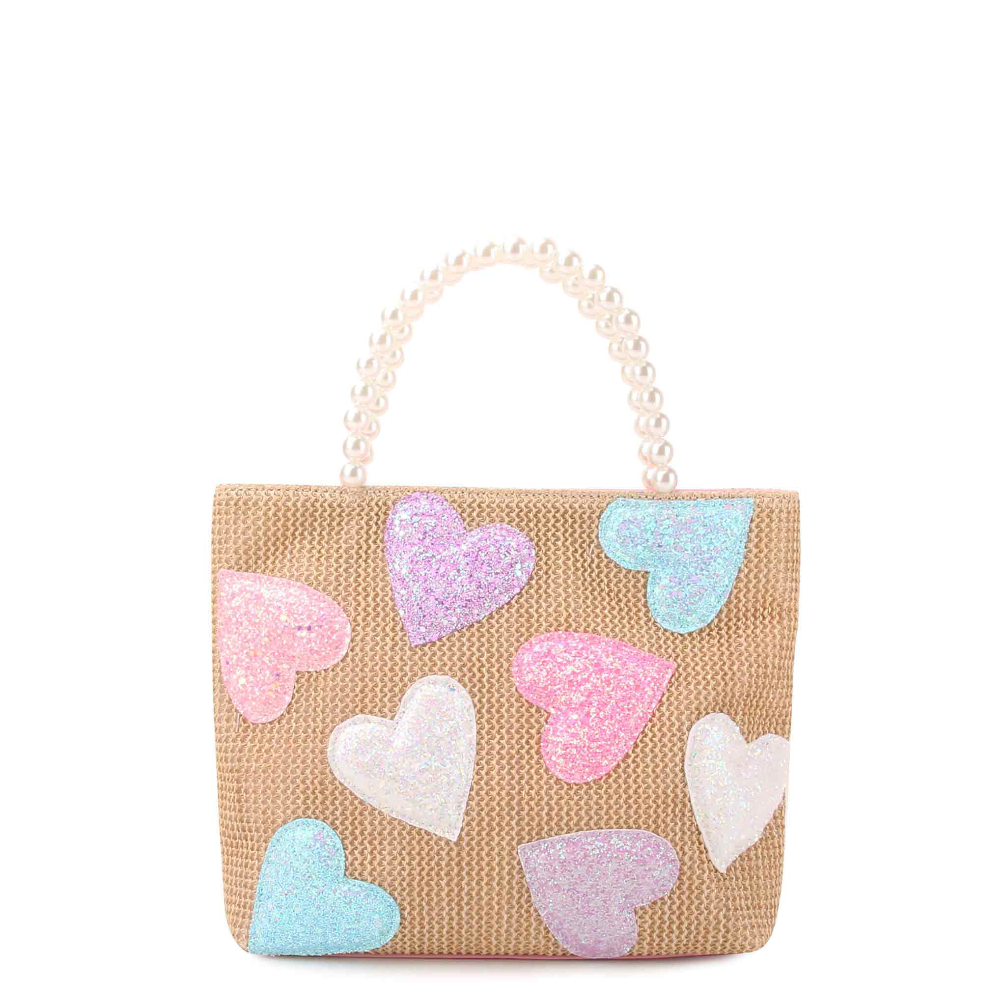 front view of a straw mini tote covered in glitter heart patches with a pearl handle