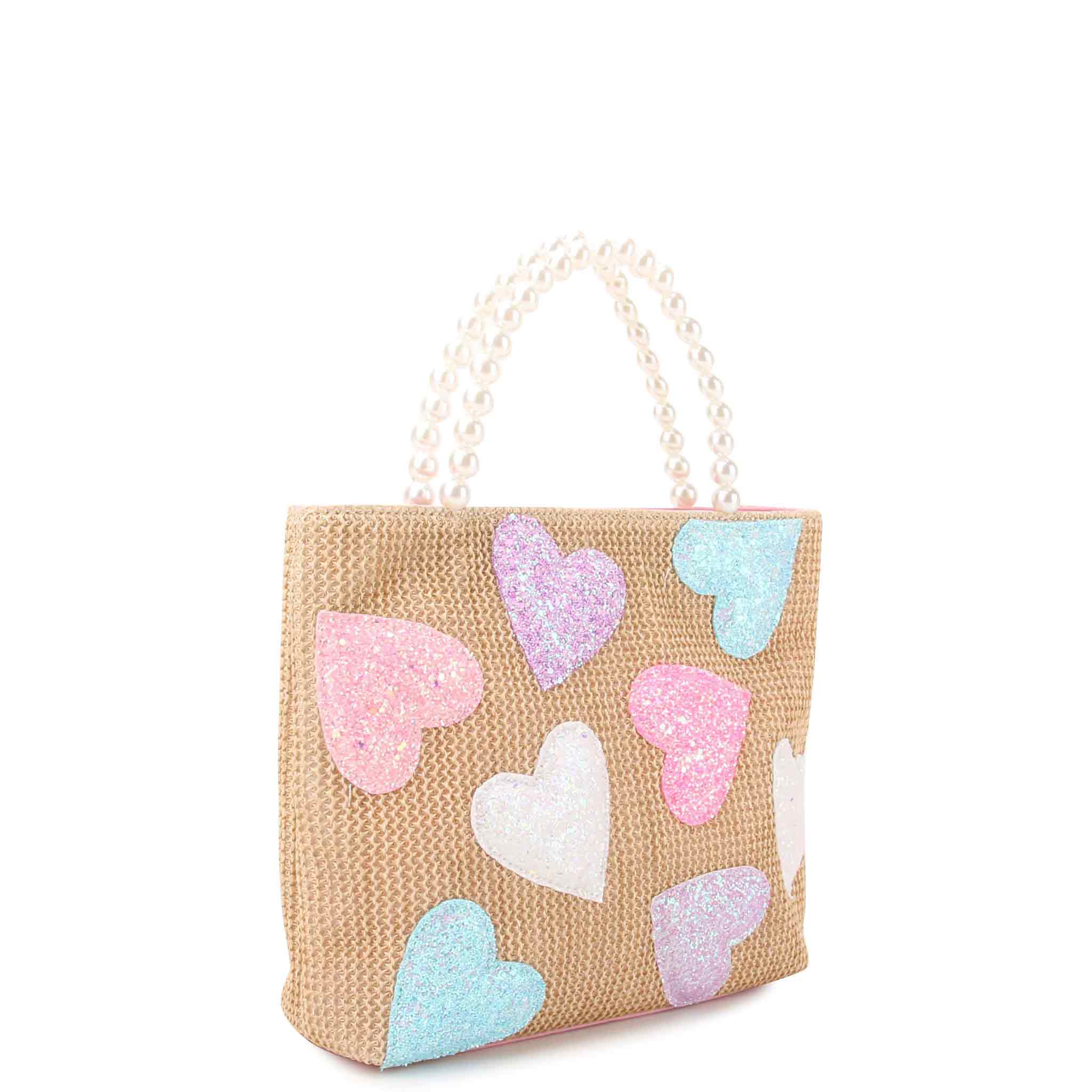 side view of a straw mini tote covered in glitter heart patches with a pearl handle