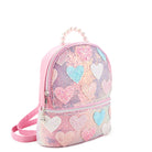 Side view of  a pink sequins mini backpack with glitter pastel heart patches and a pearl handle