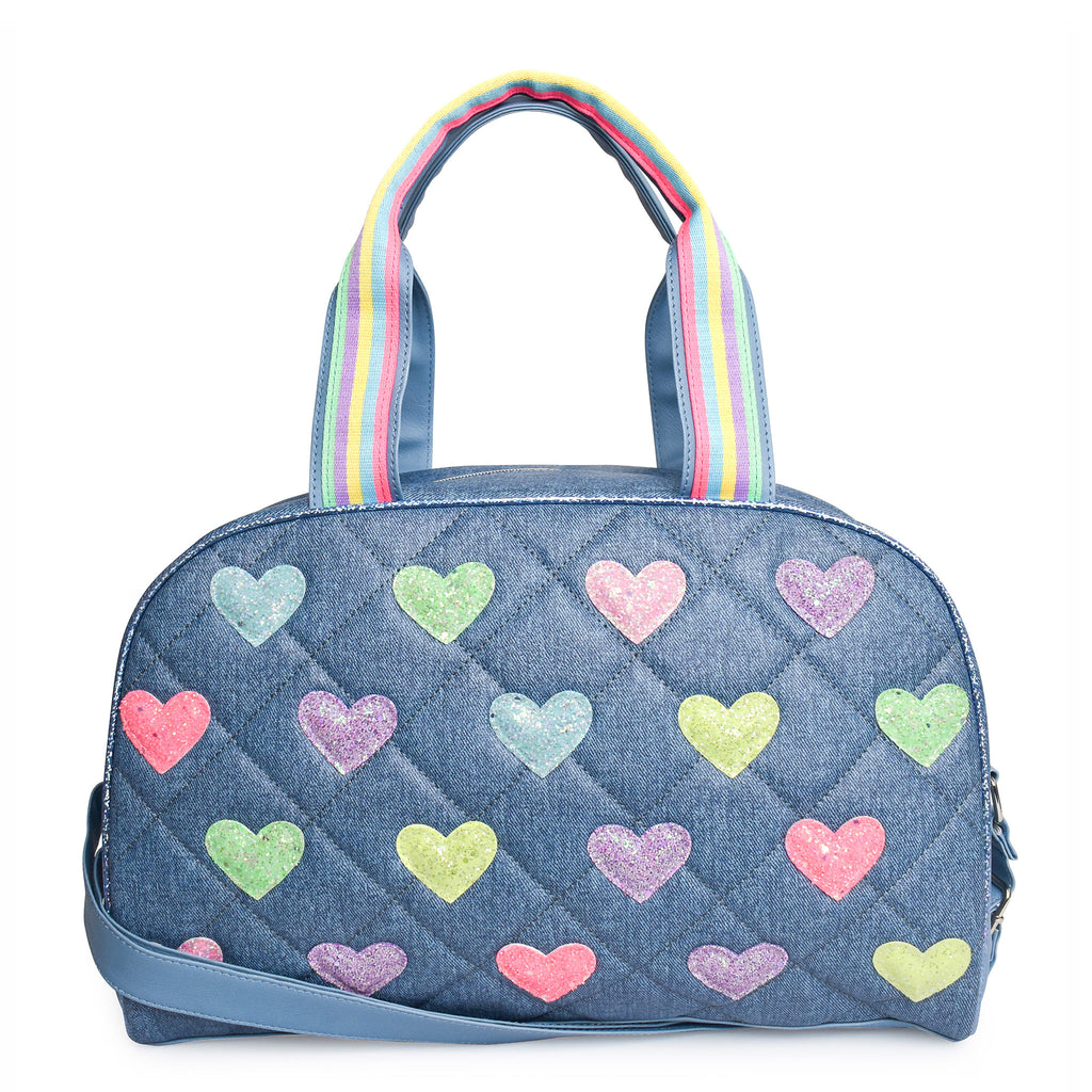 Front view of a denim quilted medium duffle bag with glitter heart patches and shoulder strap