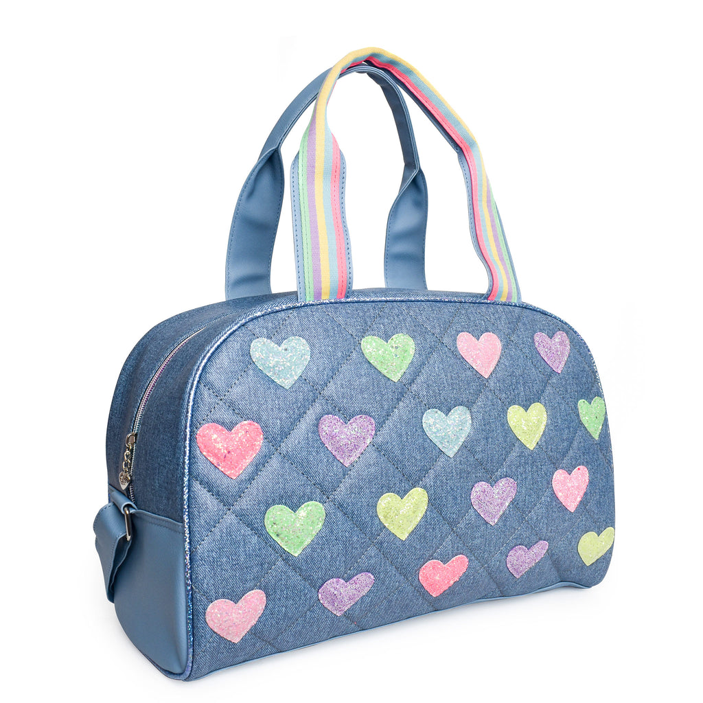 Side view of a denim quilted medium duffle bag with glitter heart patches and shoulder strap