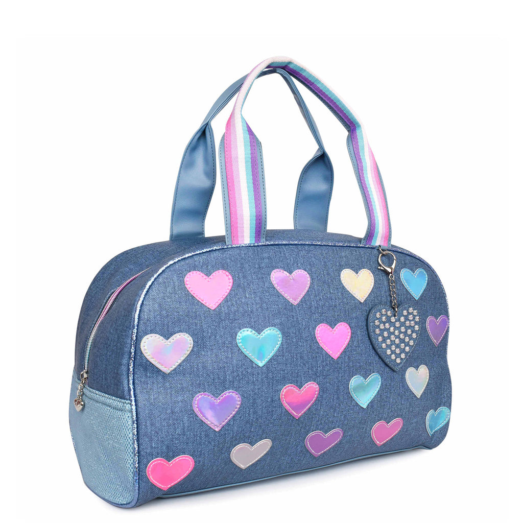 Side view of denim-printed medium duffle bag with reflective heart patches and heart-shaped keychain