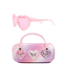 view of an ombre sunglass case with  confetti heart patches along with a pair of pink heart shaped sunglasses 