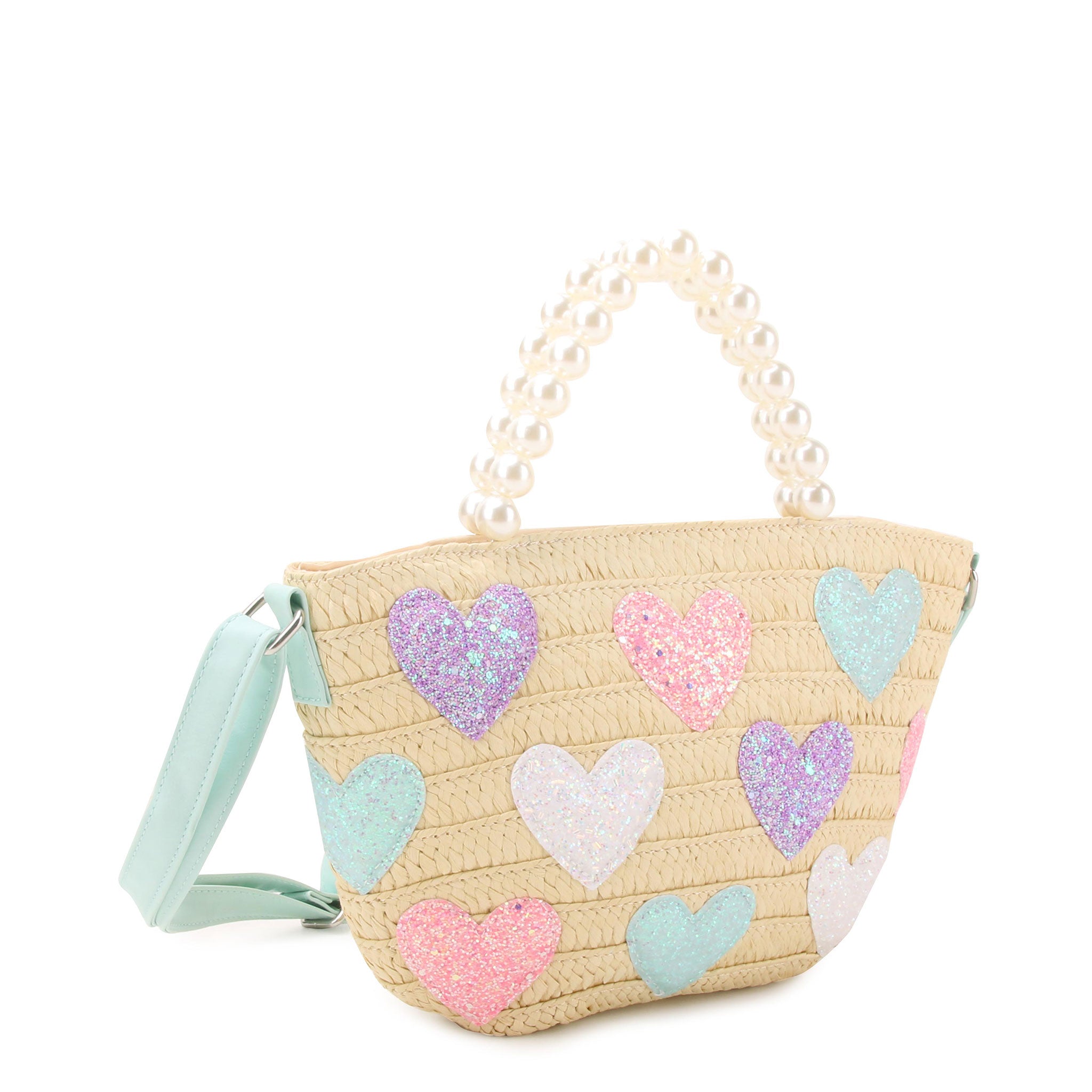 side view of a straw tote bag with glitter heart patches and a pearl beaded top handle