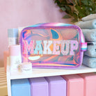 photoshoot photo of a clear glazed pouch with glitter varsity lettering 'Makeup'