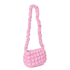 side view of a long handle scrunch hand bag in a light pink
